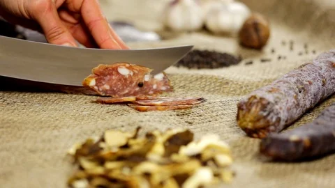 Salami sausage is being cut to thin slices Stock Footage 102586308