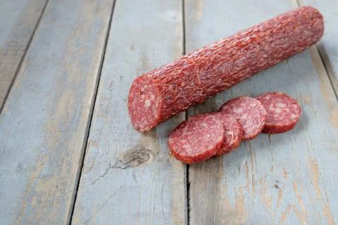 Salami sausage on the rustic table Stock Photos