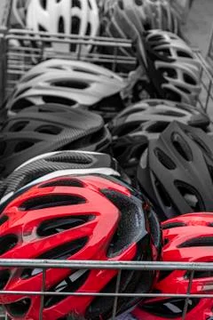 Sale of bicycle helmets of different colors. bicycle helmet in the basket Stock Photos