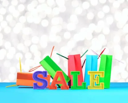 Sale written by colorful letters on the background of shopping bags Stock Photos