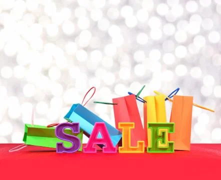 Sale written by colorful letters on the background of shopping bags Stock Photos