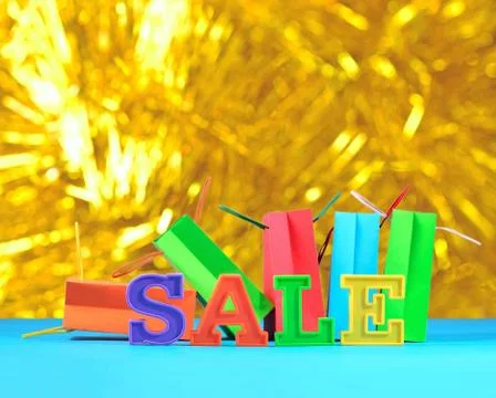 Sale written by colorful letters on the background of shopping bags Stock Photos
