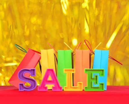 Sale written by colorful letters on the background of shopping bags Stock Photos