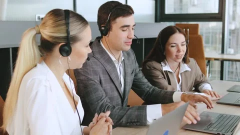 Sales agents work together in a modern office environment to assist clients Stock Footage 320911732