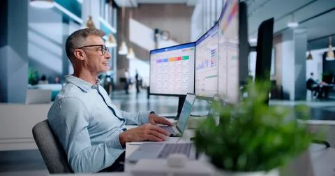 Sales Analyst Reviews Customer Data On Laptop To Improve Sales Strategy. Stock Photos