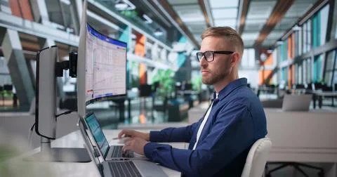 Sales Analyst Studies Customer Data Using Curved Ultrawide Desktop Computer. 库存照片