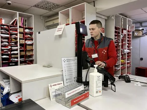 Sales assistant at checkout checks documents of client who takes delivery or Stock Photos