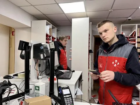Sales assistant at checkout checks documents of client who takes delivery or Stock Photos