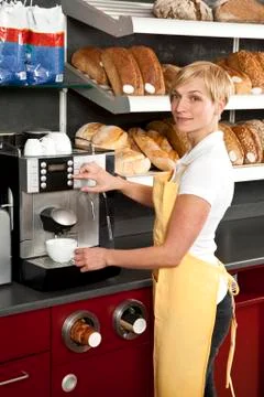 A sales clerk using an espresso maker in a bakery cafe Stock Photos