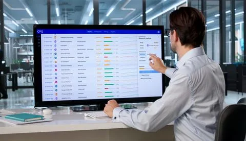 Sales Manager Configures Pricing Software On Touchscreen Computer Efficiently Foto stock