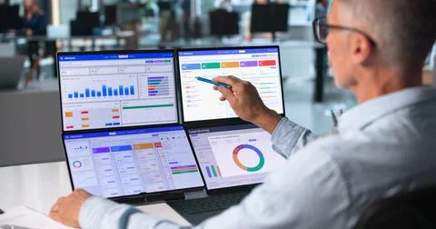 Sales Manager Examines Customer Data Using Dual Touchscreen Laptops Efficient 写真素材
