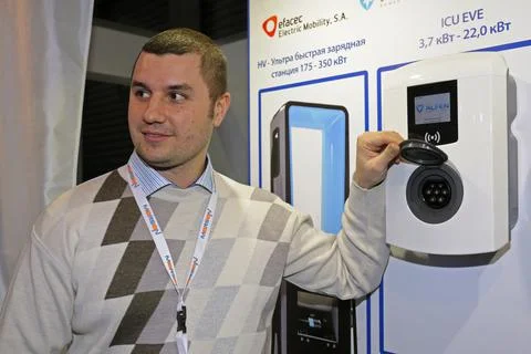 Sales manager explaining how electric car charging station works Stock Photos