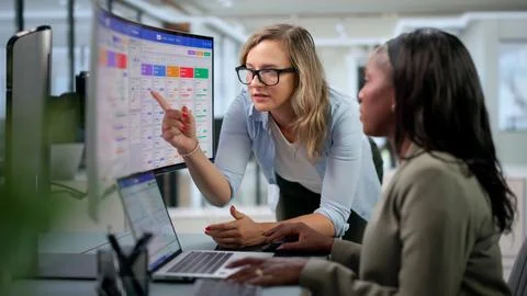 Sales Manager Leads Team Tracking Client Data Using CRM On Laptop. Stock Photos