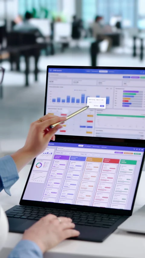 Sales Manager Reviewing CRM Data On Dual Touchscreen Laptops Stock Footage 345326053