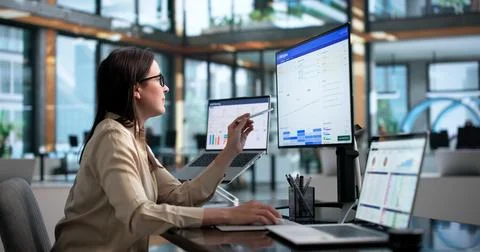 Sales Manager Reviewing Customer Data On Laptop Using CRM Software. Stock Photos
