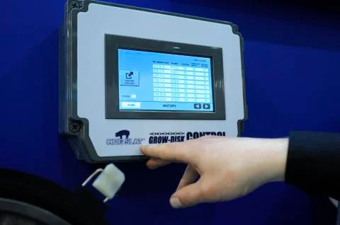 Sales manager touching control panel of a feed transportation system, used in Stock Photos
