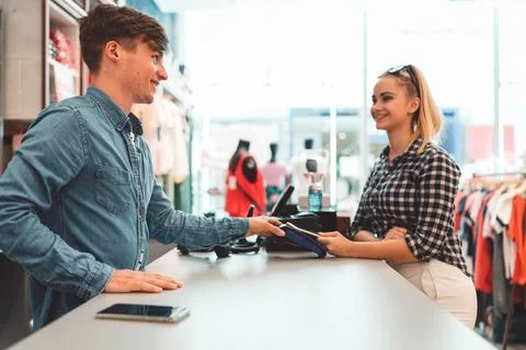 Sales perso, young man holding a card reader for the costumer to pay for her Stock Photos