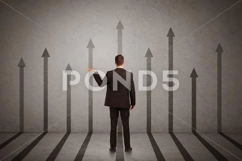 Sales person looking at arrows pointing up on the wall concept Stock Photos