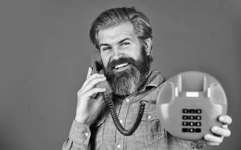 Sales script. Bearded man phone conversation. Retro phone. Outdated technology Stock Photos