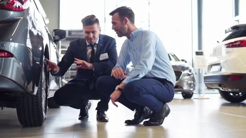 Salesman with client checking tires  Stock Footage 76602624