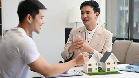 Salesman Hands On House Model , Small Toy House Small Mortgage Property ins.. Stock Footage 312980812