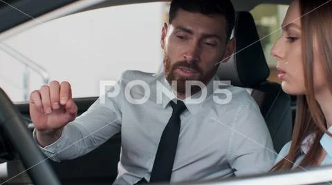 Salesman shows the car features for client. The car is new. Salesman do the best Stock Photos