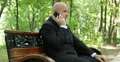 Salesman Sitting Relaxed on Park Bench in Working Break and Talk to Mobile Phone 4k or 4k+ Resolution
