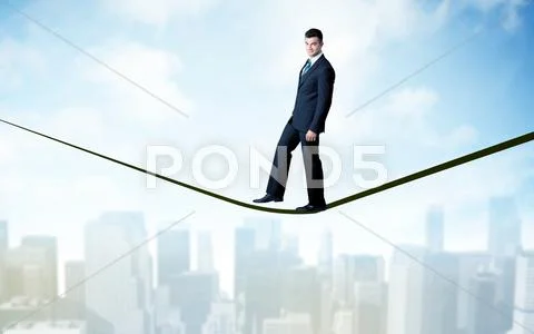 Salesman walking on rope above the city Stock Photos