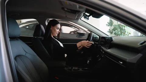 Saleswoman testing dashboard navigation system in new car Stock Footage 315086507