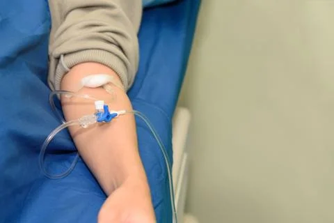 Saline intravenous or iv solution with patient arm Foto stock