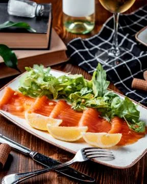 Salmon carpaccio with lemon on the table Stock Photos