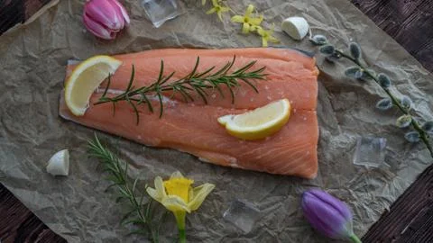Salmon for the festive Easter table with rosemary and lemon on crumpled paper. Stock Photos