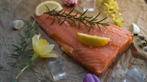 Salmon for the festive Easter table with rosemary and lemon on crumpled paper. Stock Photos
