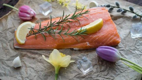 Salmon for the festive Easter table with rosemary and lemon on crumpled paper. Stock Photos