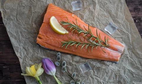 Salmon for the festive Easter table with rosemary and lemon on crumpled paper. Stock Photos