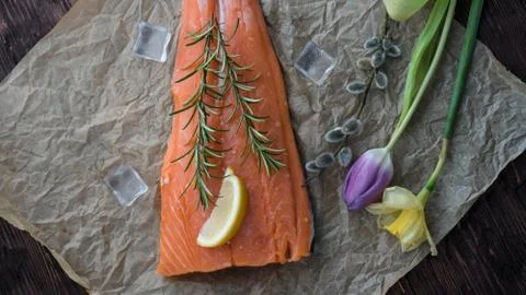 Salmon for the festive Easter table with rosemary and lemon on crumpled paper. Stock Photos