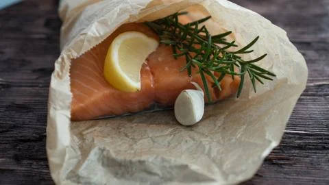 Salmon for the festive Easter table with rosemary and lemon on crumpled paper. Stock Photos