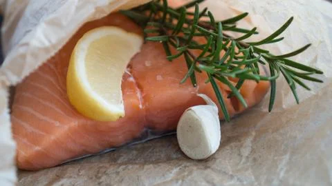 Salmon for the festive Easter table with rosemary and lemon on crumpled paper. Stock Photos