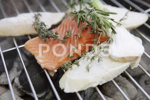 A Salmon Fillet And Slices Of Bread On A Barbecue With Bunches Of Herbs