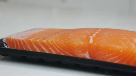 Salmon fillet portion on black plastic supermarket tray Vídeo Stock 330319827