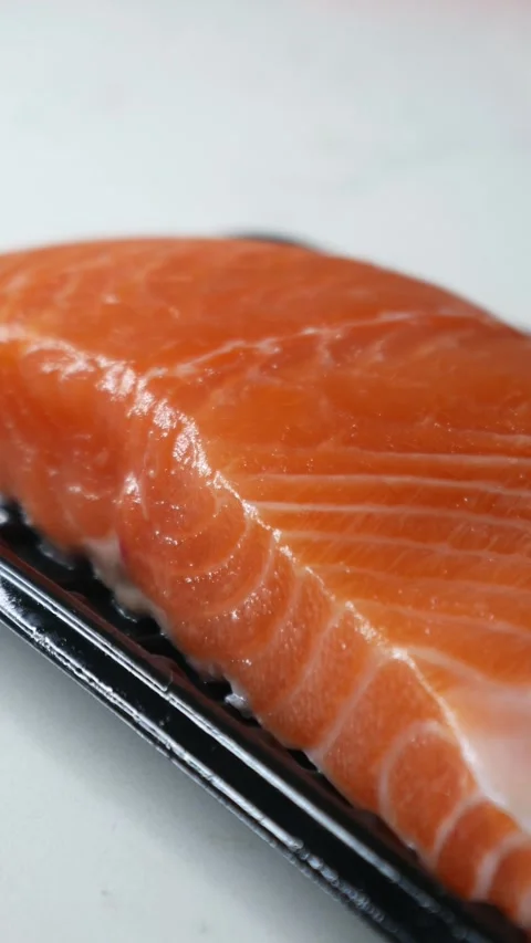 Salmon fillet portion on black plastic supermarket tray Stockbeeldmateriaal 330319837
