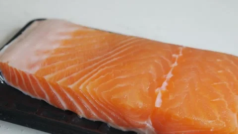 Salmon fillet portion on black plastic supermarket tray Vidéo 330566406