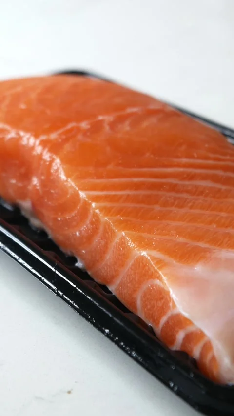 Salmon fillet portion on black plastic supermarket tray Video stock 332292888