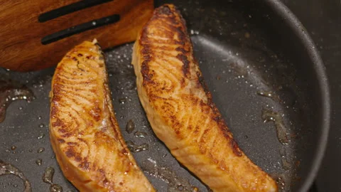Salmon Fillets Gently Cooking in Pan with Wooden Spatula with Soy Sauce Stock Footage 346223654