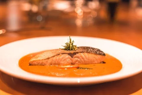 Salmon fish with curry in the dish on the table dinner. Stock Photos