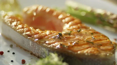 Salmon fish steak and vegetable. Bottle of Olive oil pouring on salmon fish. Stock Footage 132974563