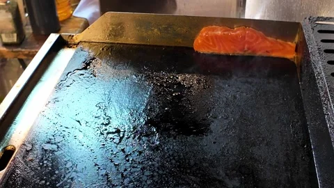 Salmon fish steak frying on flat griddle 스톡 동영상 347528847
