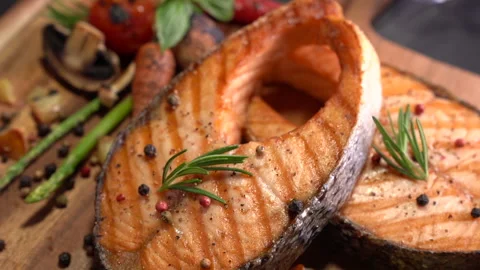 Salmon fish steak with herbs and vegetables on wooden background Видео 148801133