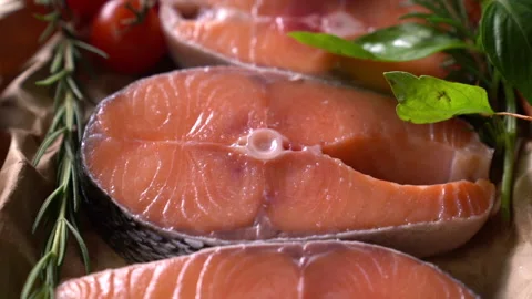 Salmon fish steak with herbs and vegetables on black stone background Stockbeeldmateriaal 149293757