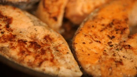 Salmon fried in a pan Stock Footage 99792363